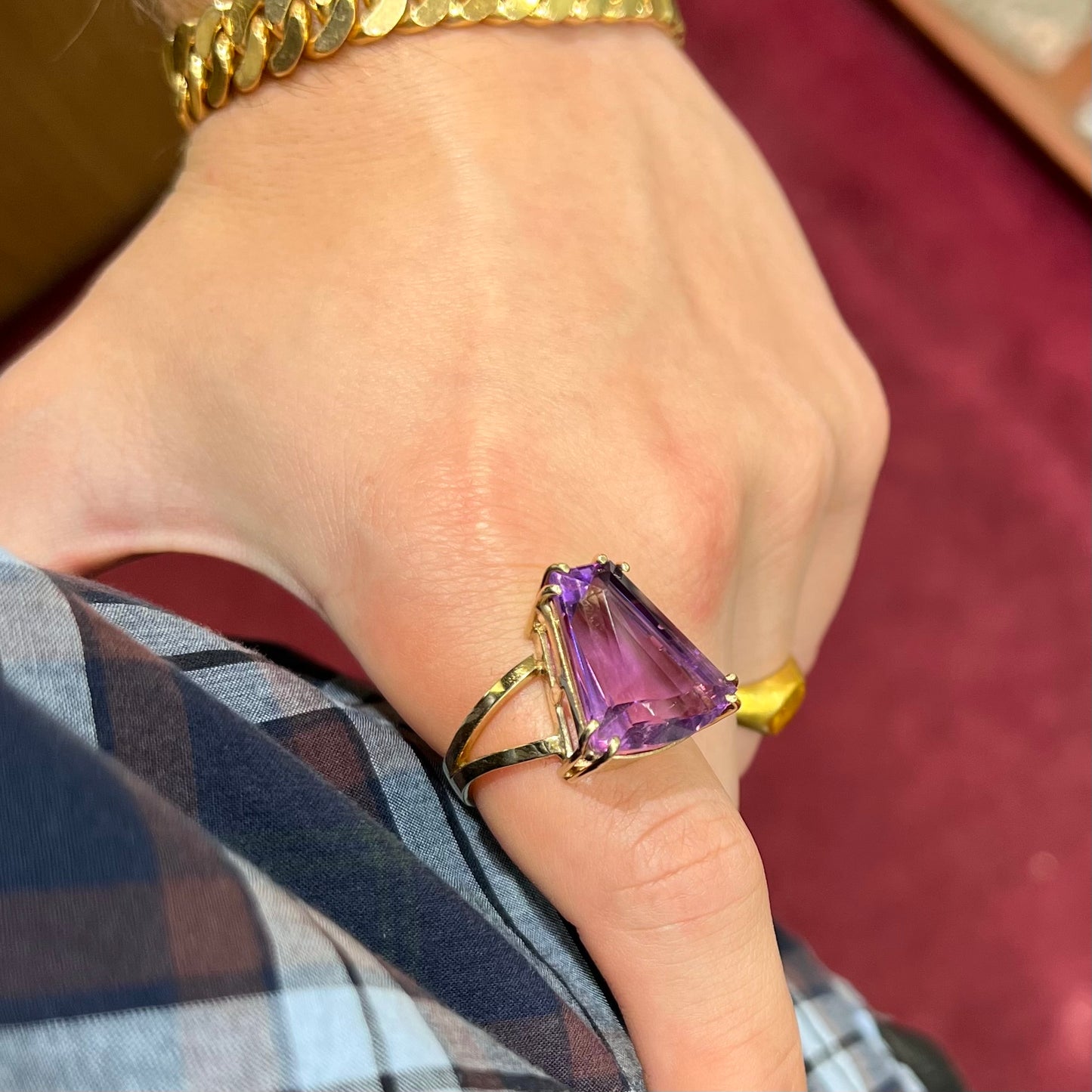 A ladies' yellow gold cocktail ring set with a shield cut purple amethyst gemstone.