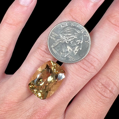 A loose, cushion cut golden beryl stone.