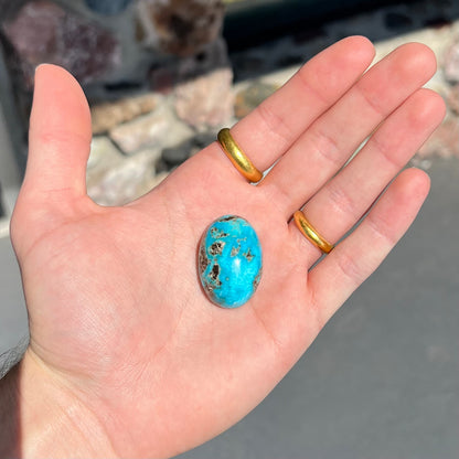 A loose, oval cabochon cut turquoise stone from Kingman, Arizona.