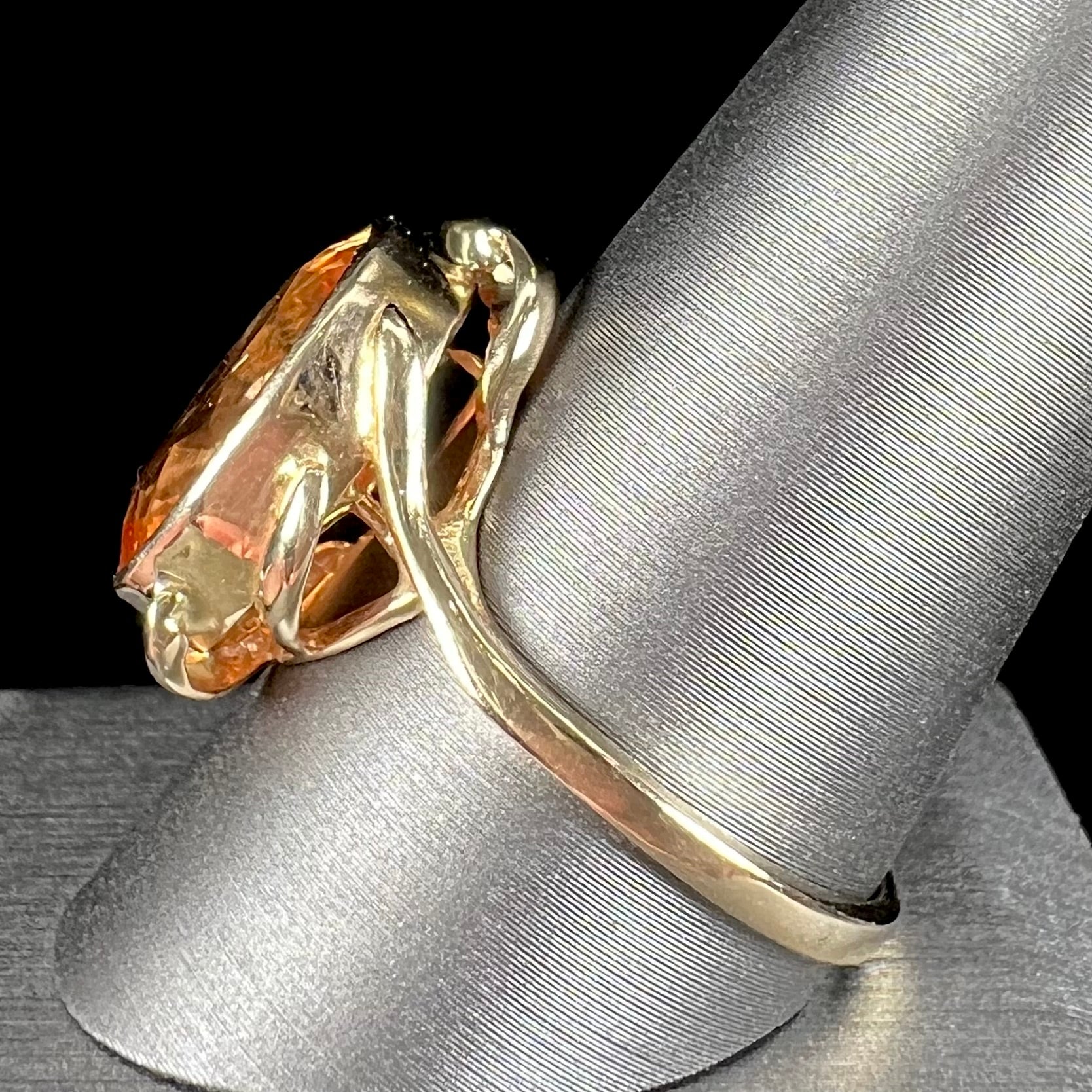 A ladies' yellow gold solitaire ring set with an 8.00 carat oval cut orange hessonite garnet.