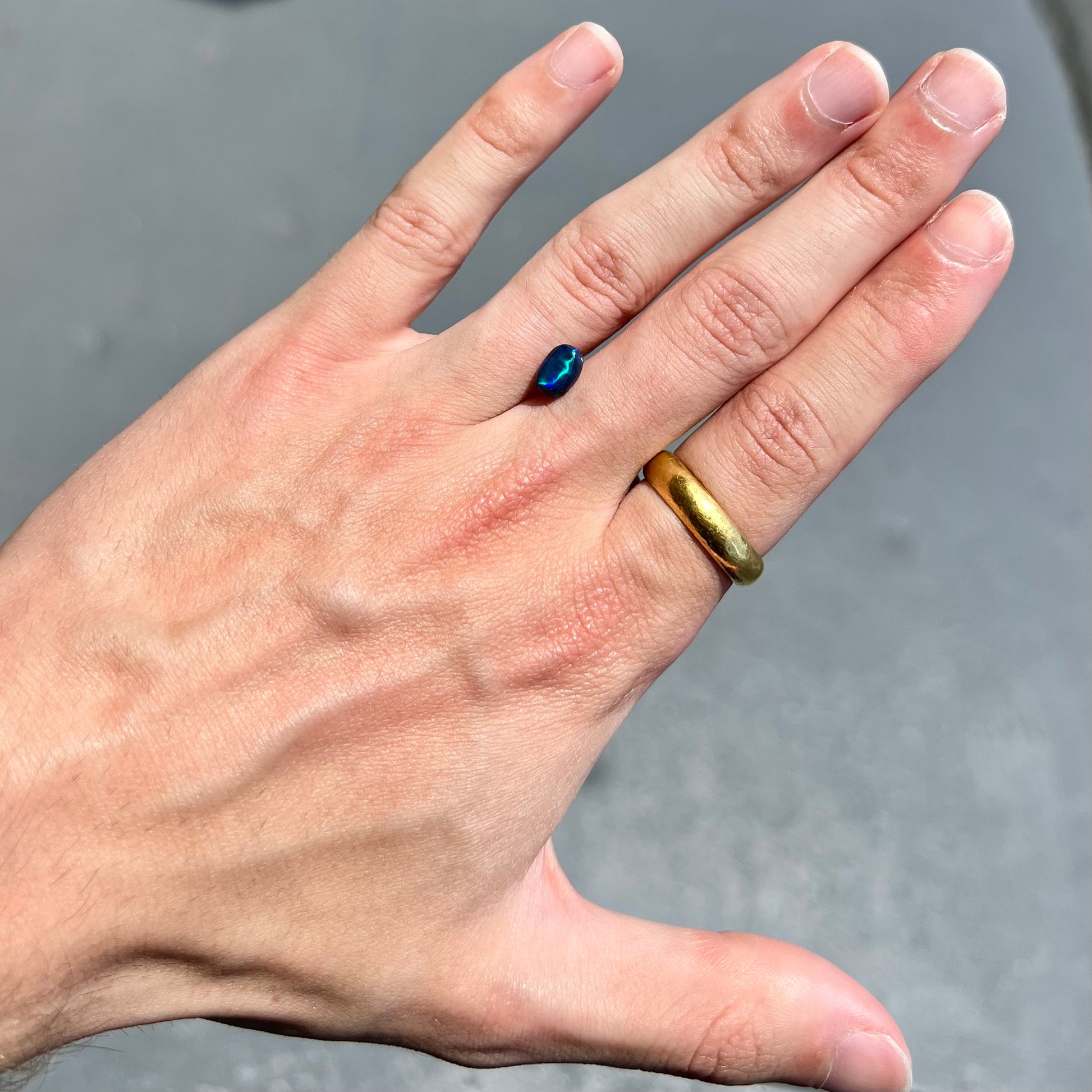 A loose black opal from Lightning Ridge, Australia.  The opal displays a blue cat's eye pattern.