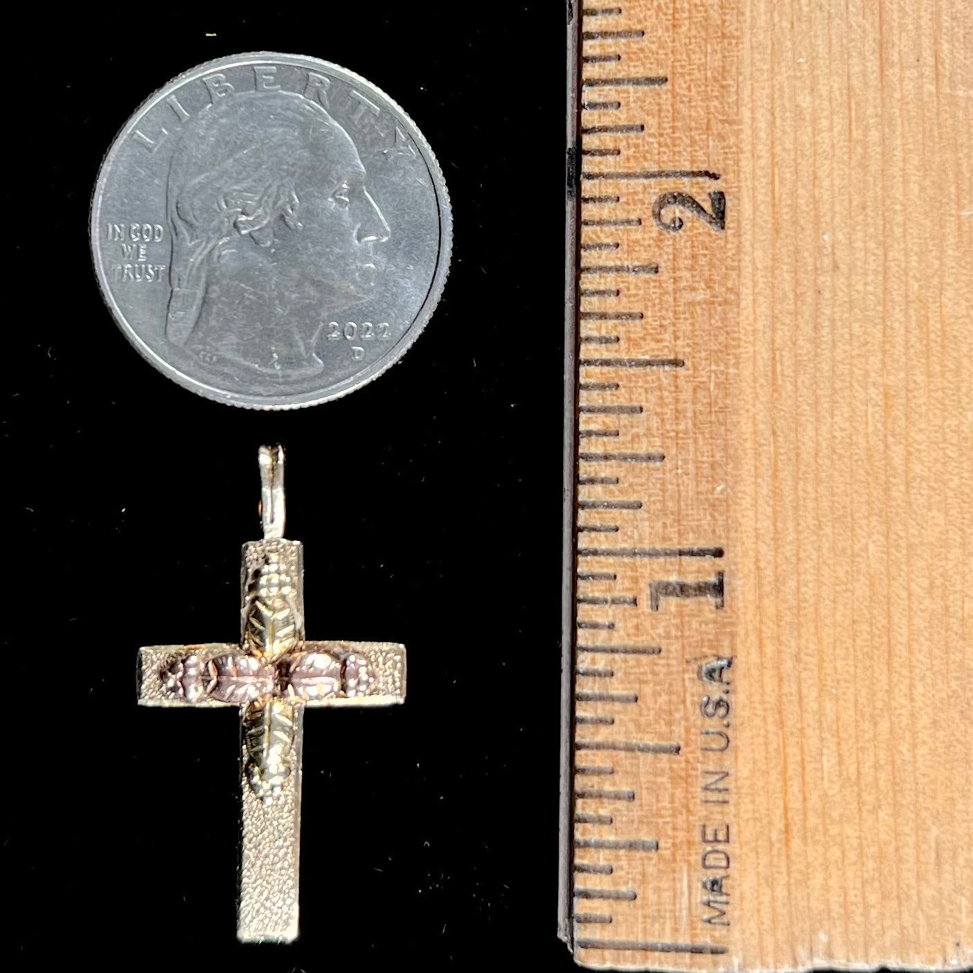 A cross made from yellow and rose gold Black Hills gold.  The cross features a leaf design.