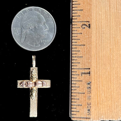 A cross made from yellow and rose gold Black Hills gold.  The cross features a leaf design.