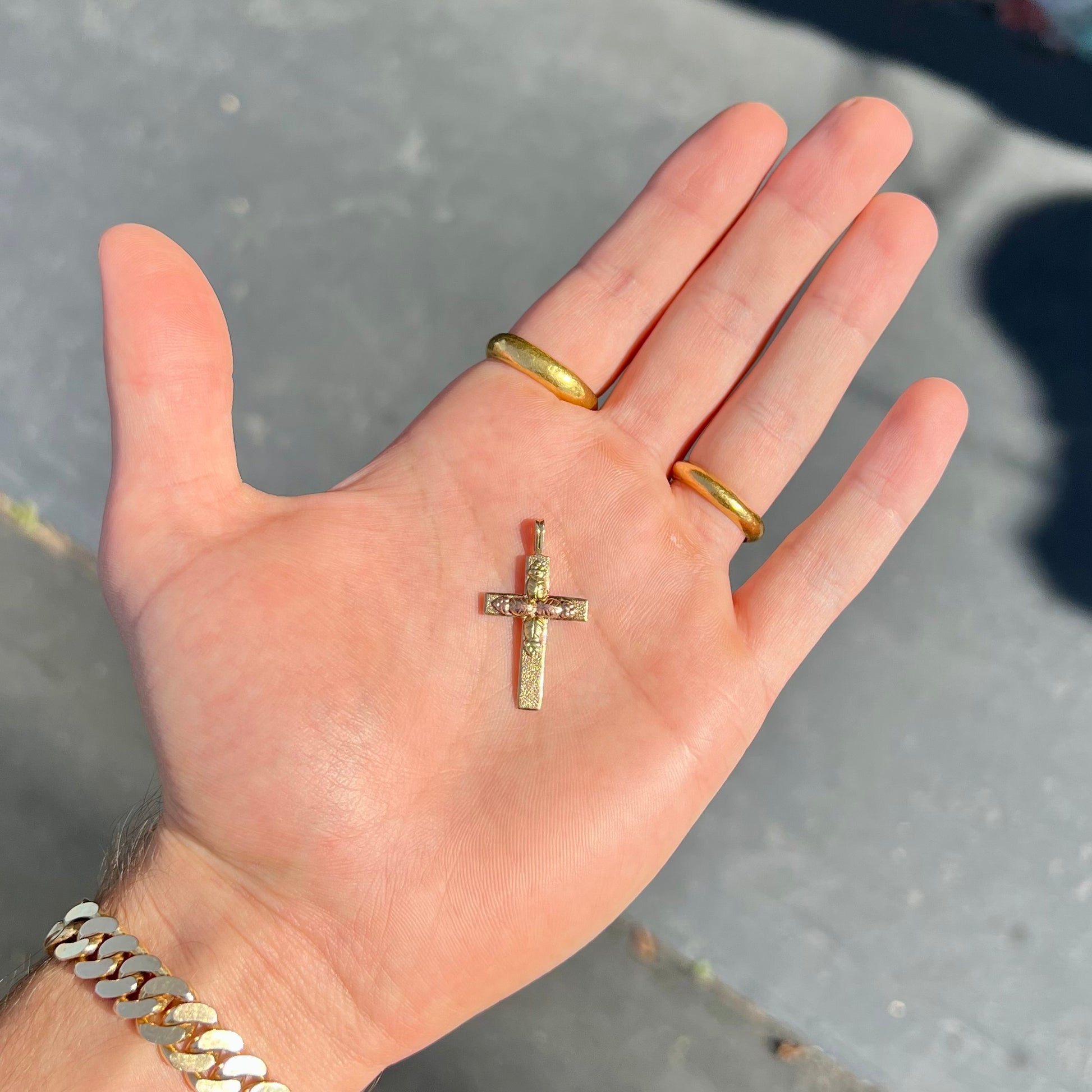 A cross made from yellow and rose gold Black Hills gold.  The cross features a leaf design.