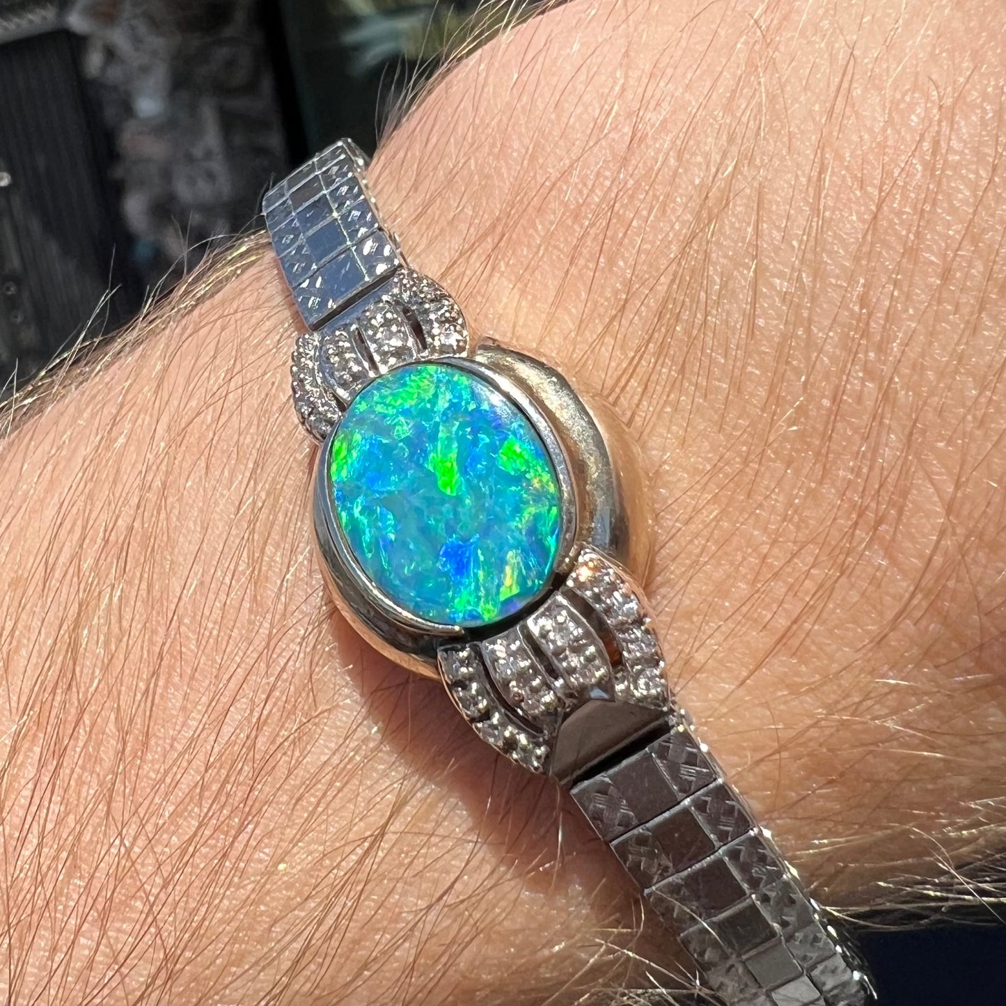 A ladies' art deco style white gold and stainless steel bracelet set with a natural black opal doublet and diamonds.