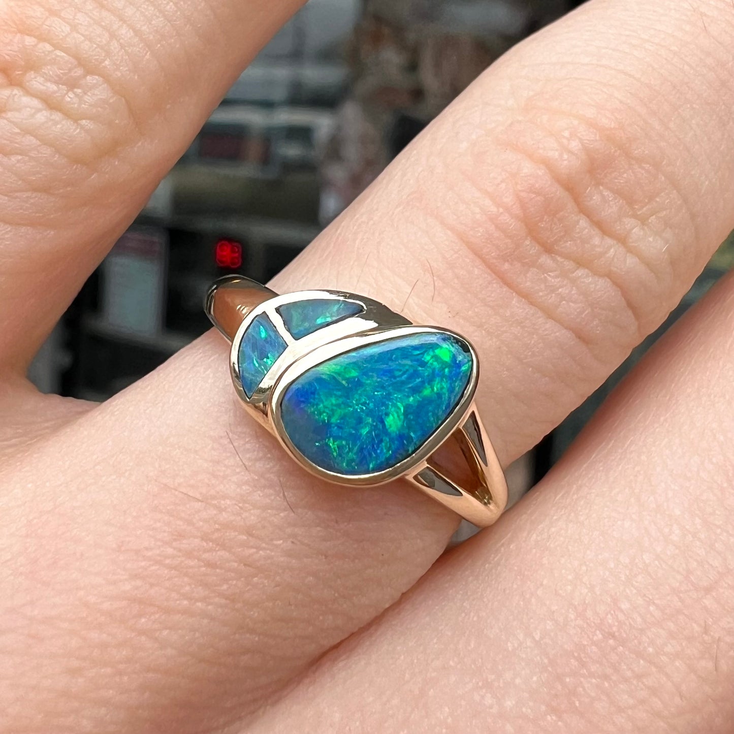 A ladies' black opal inlay ring cast in yellow gold.