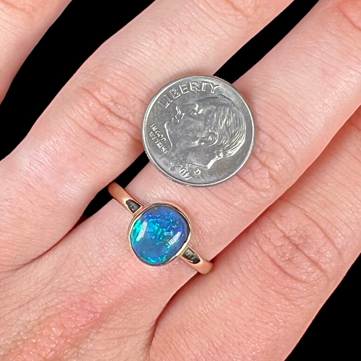 A ladies' natural black crystal opal solitaire ring handmade in 14 karat yellow gold.