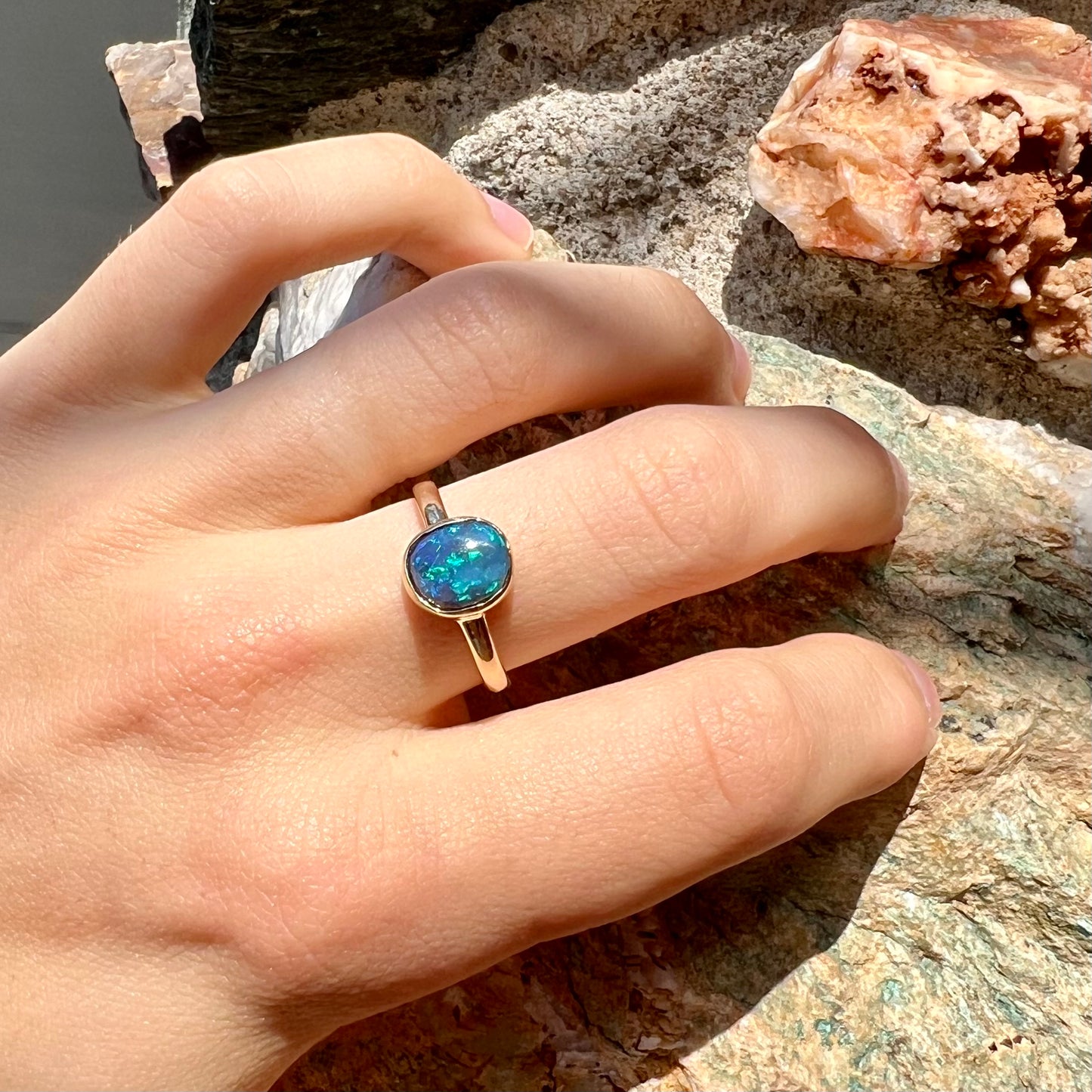 A ladies' natural black crystal opal solitaire ring handmade in 14 karat yellow gold.