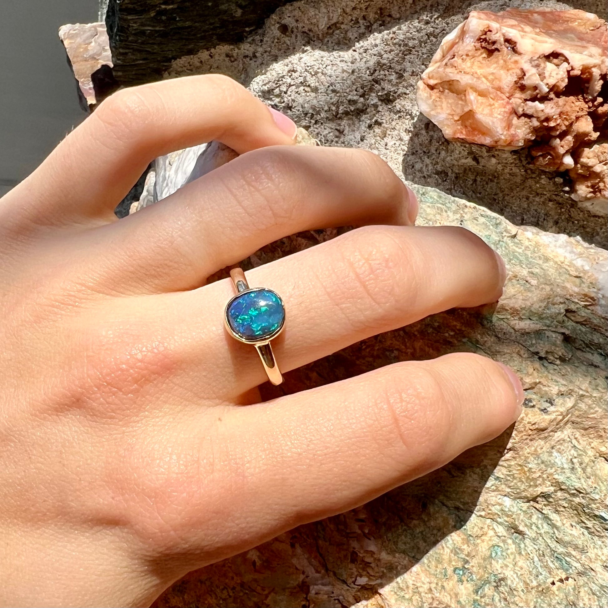 A ladies' natural black crystal opal solitaire ring handmade in 14 karat yellow gold.