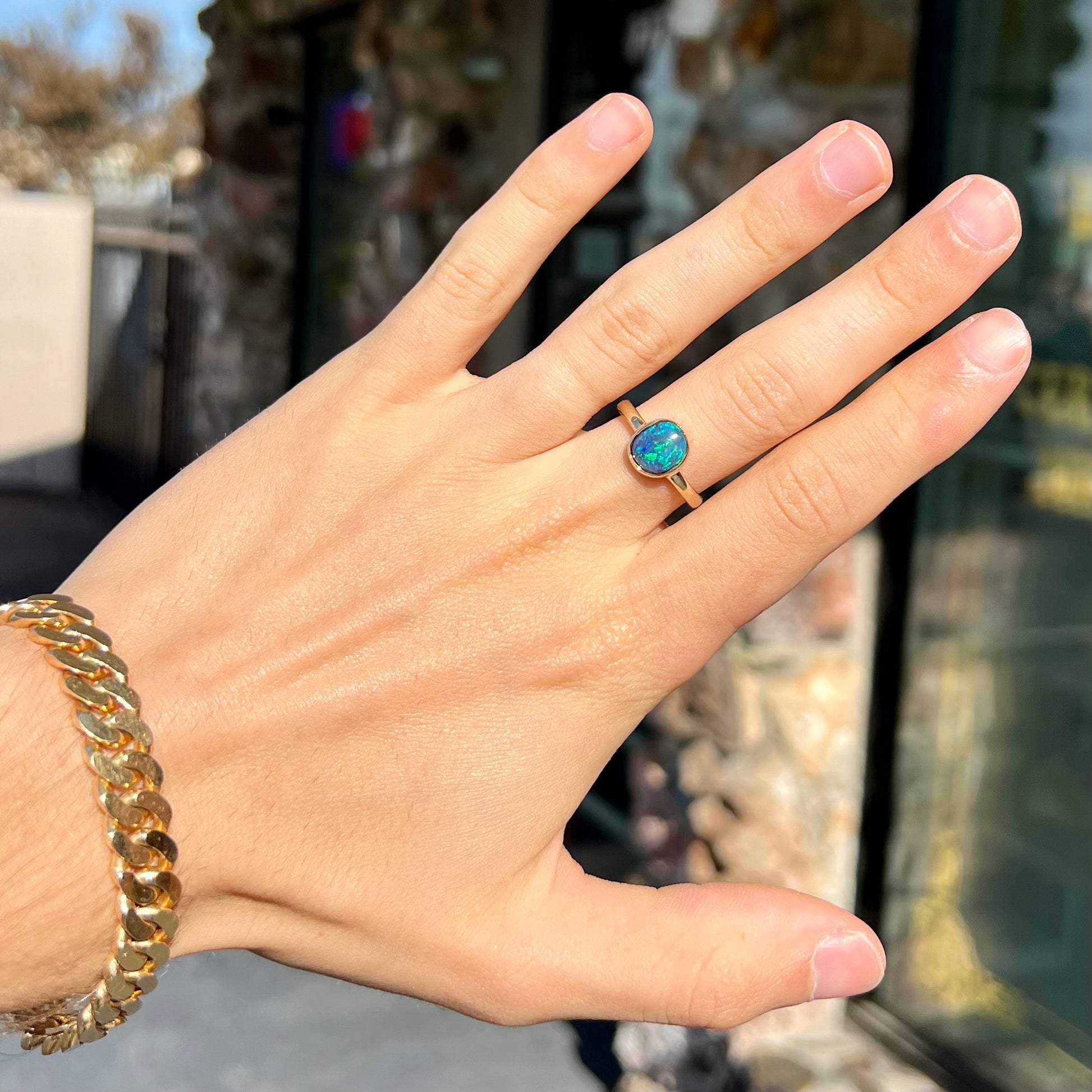 A ladies' natural black crystal opal solitaire ring handmade in 14 karat yellow gold.