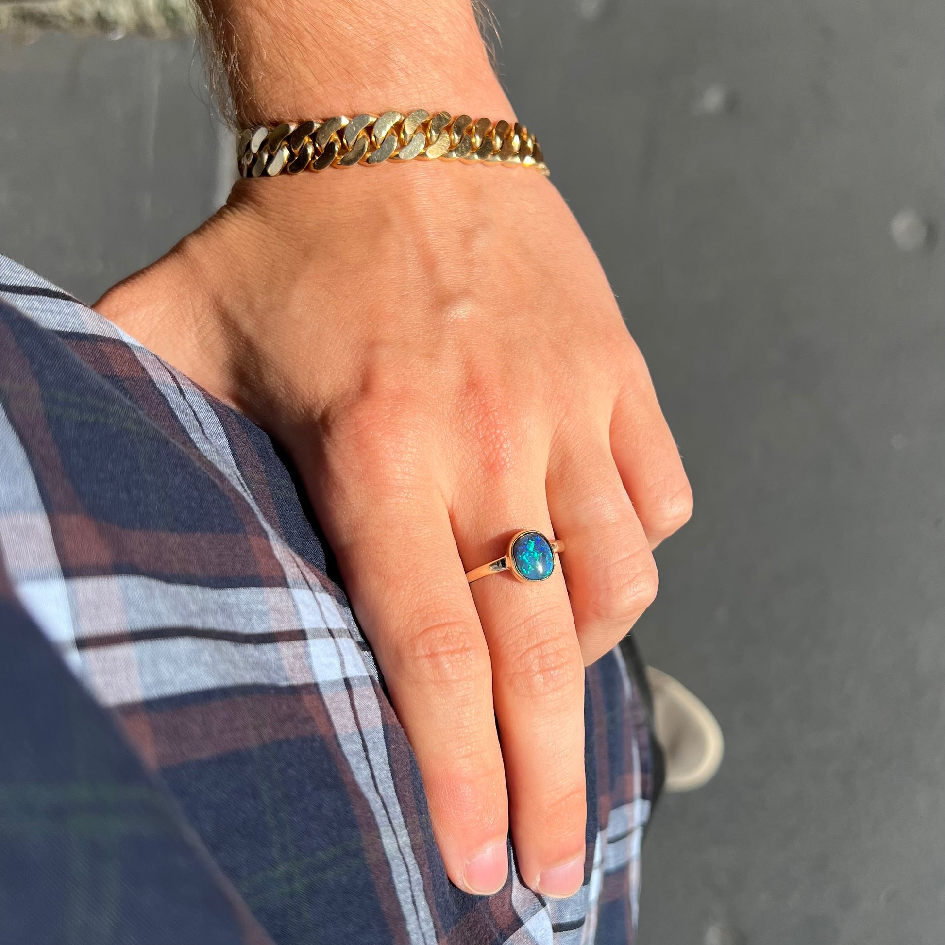 A ladies' natural black crystal opal solitaire ring handmade in 14 karat yellow gold.