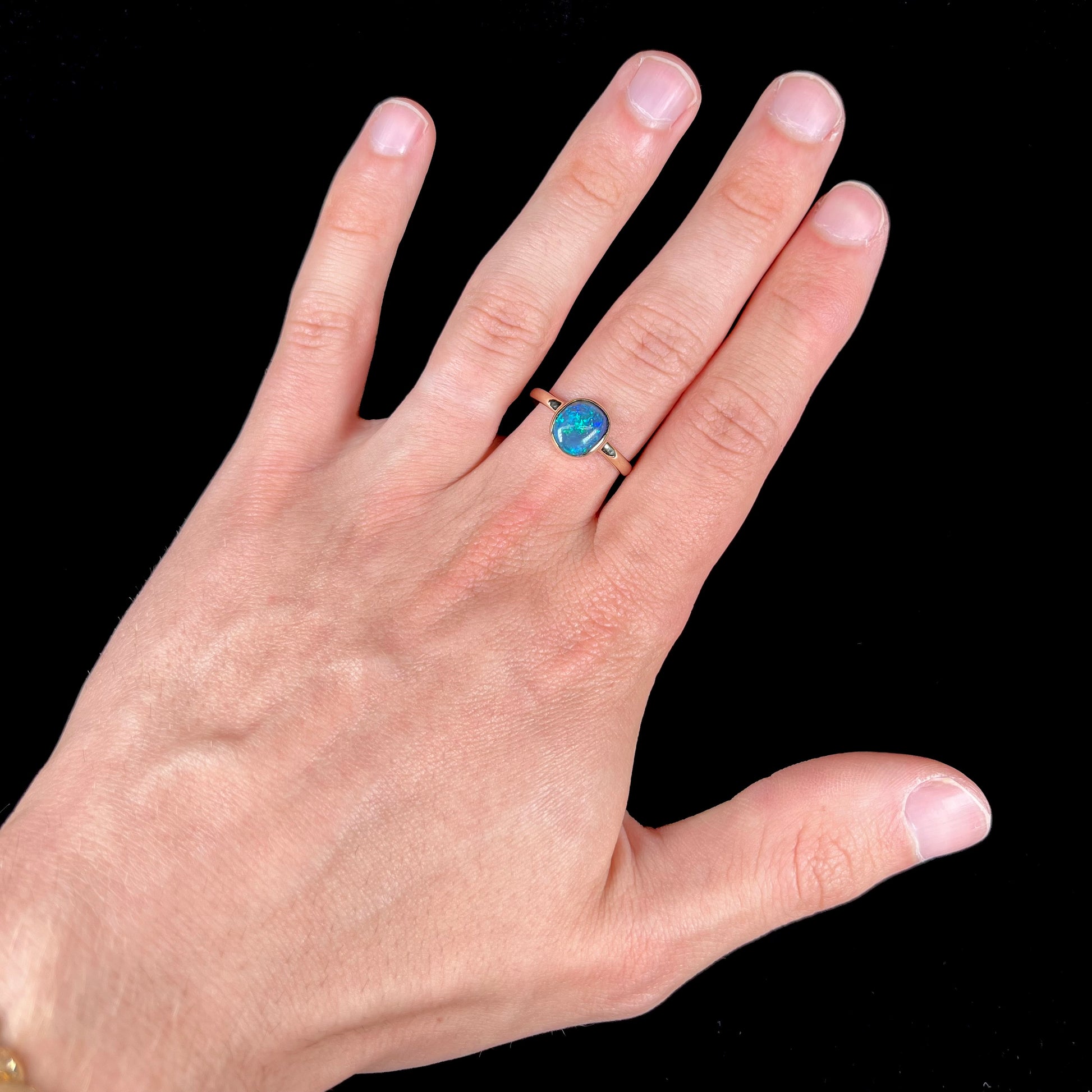 A ladies' natural black crystal opal solitaire ring handmade in 14 karat yellow gold.