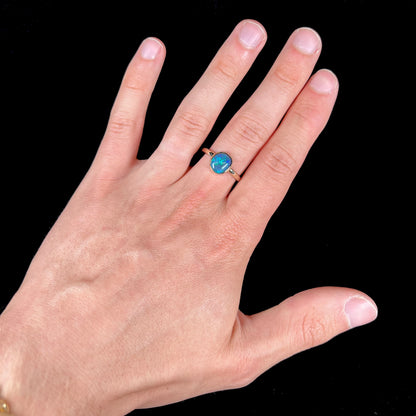A ladies' natural black crystal opal solitaire ring handmade in 14 karat yellow gold.