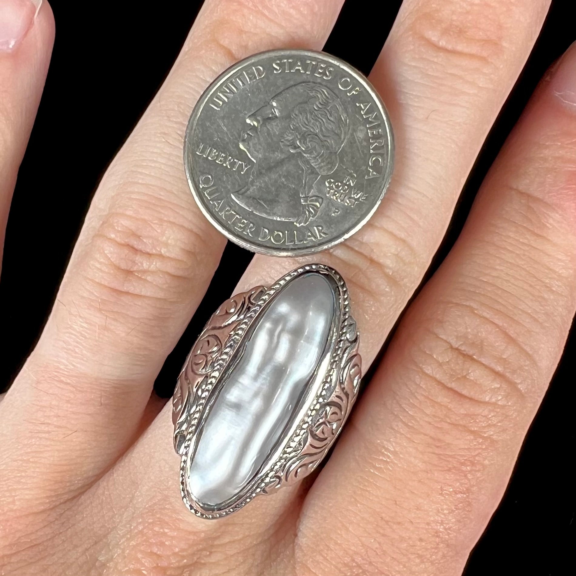 A Boho Chic style sterling silver solitaire ring set with an oval shaped, metallic silver gray mabe pearl.