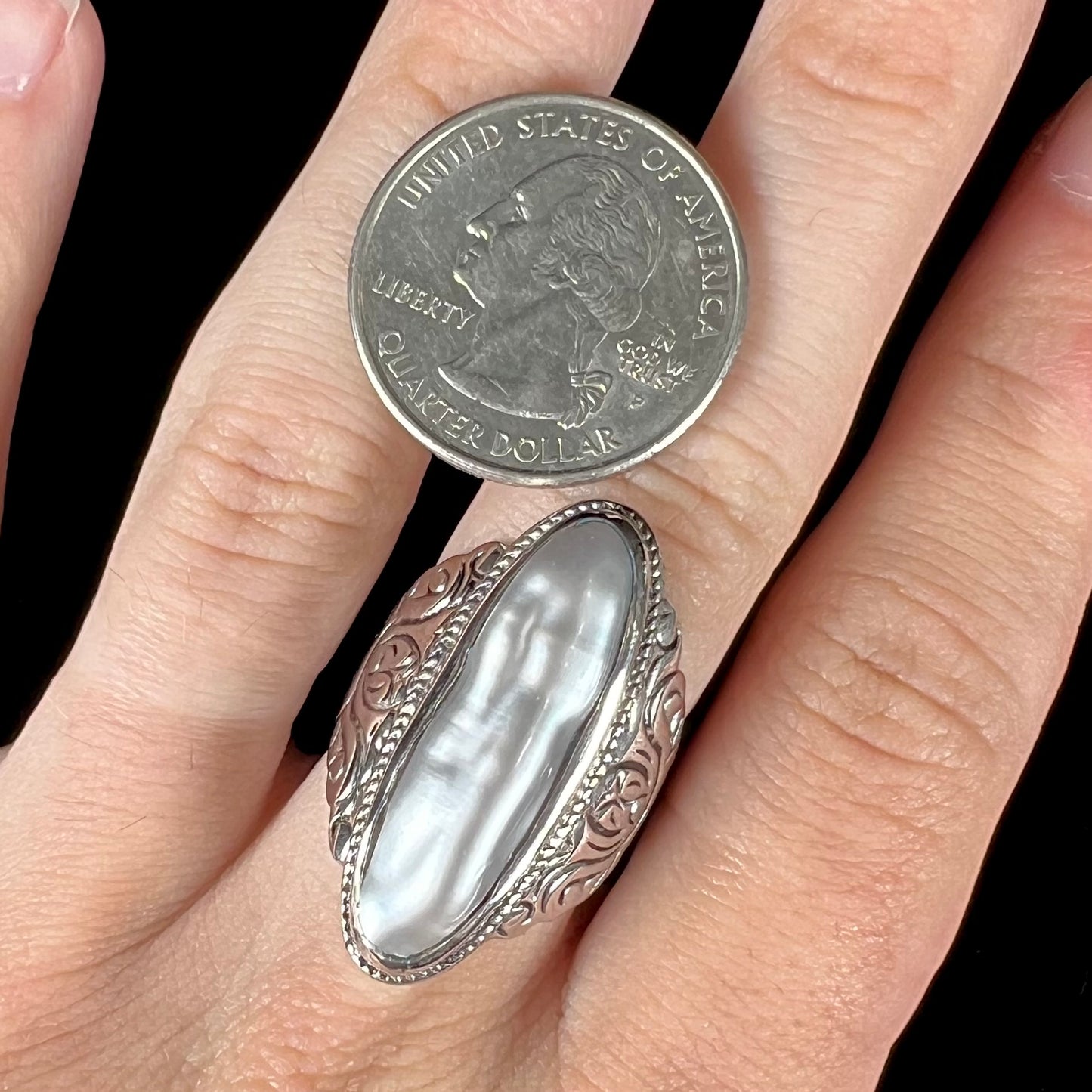 A Boho Chic style sterling silver solitaire ring set with an oval shaped, metallic silver gray mabe pearl.