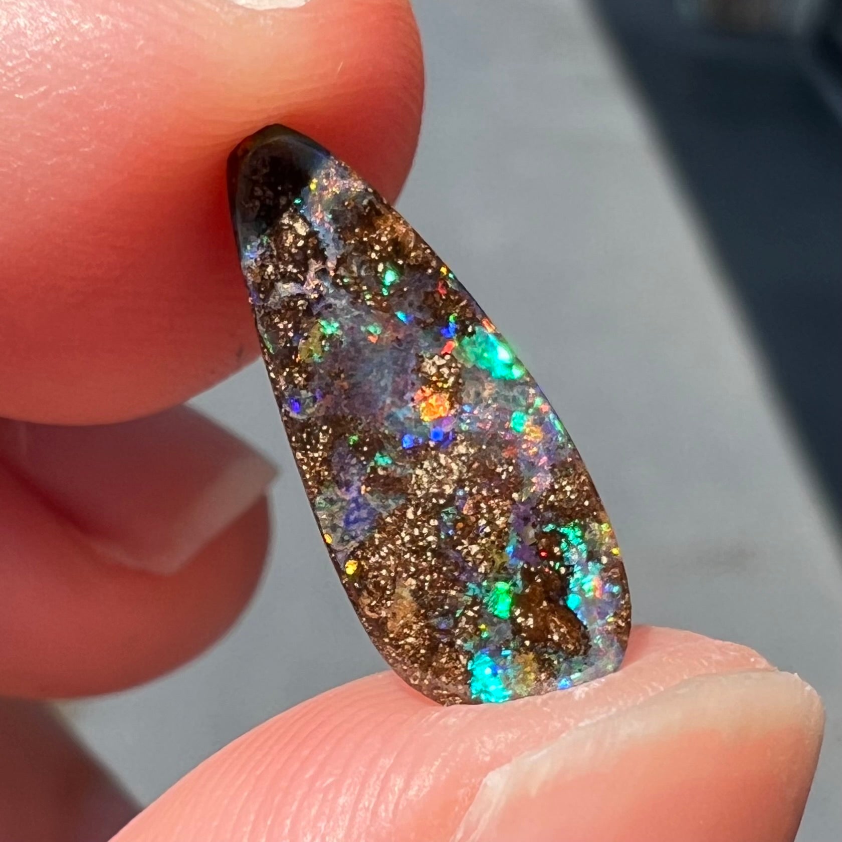A loose, pear shaped boulder opal stone from Quilpie, Australia.  The opal shines every color of the rainbow.
