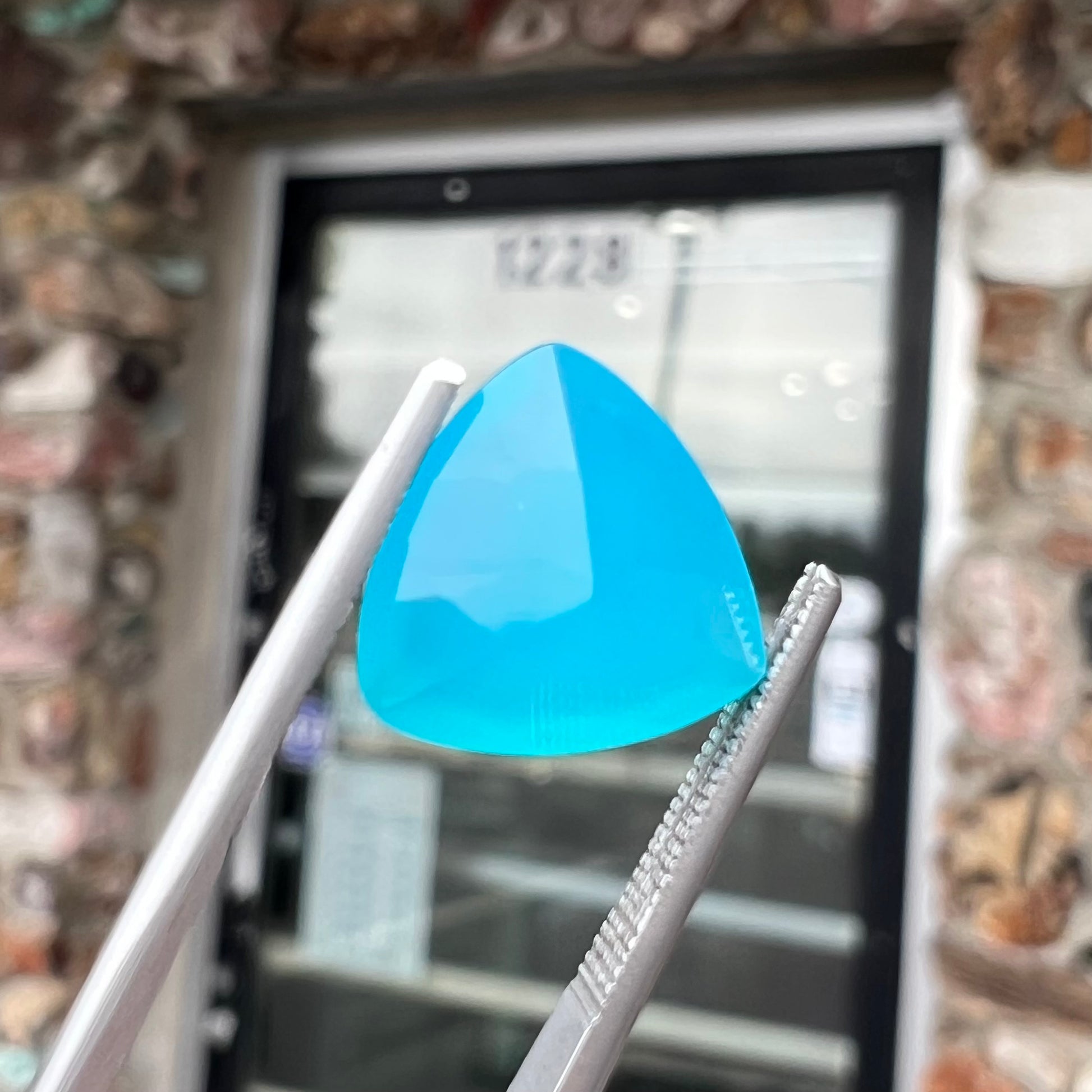 A loose, blue, trillion cut Paraiba chalcedony gemstone.