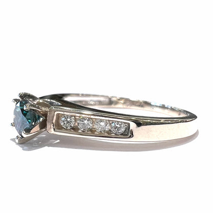 A ladies' white gold engagment ring set with a round brilliant blue diamond and channel set diamond accents.