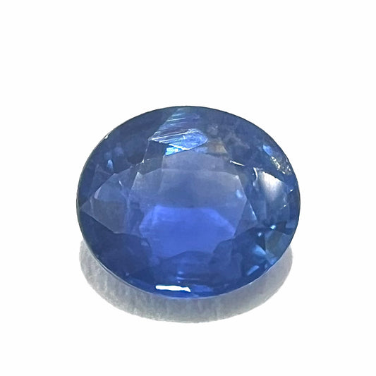 A loose, faceted oval cut natural blue sapphire.  The color is a dark cornflower blue.