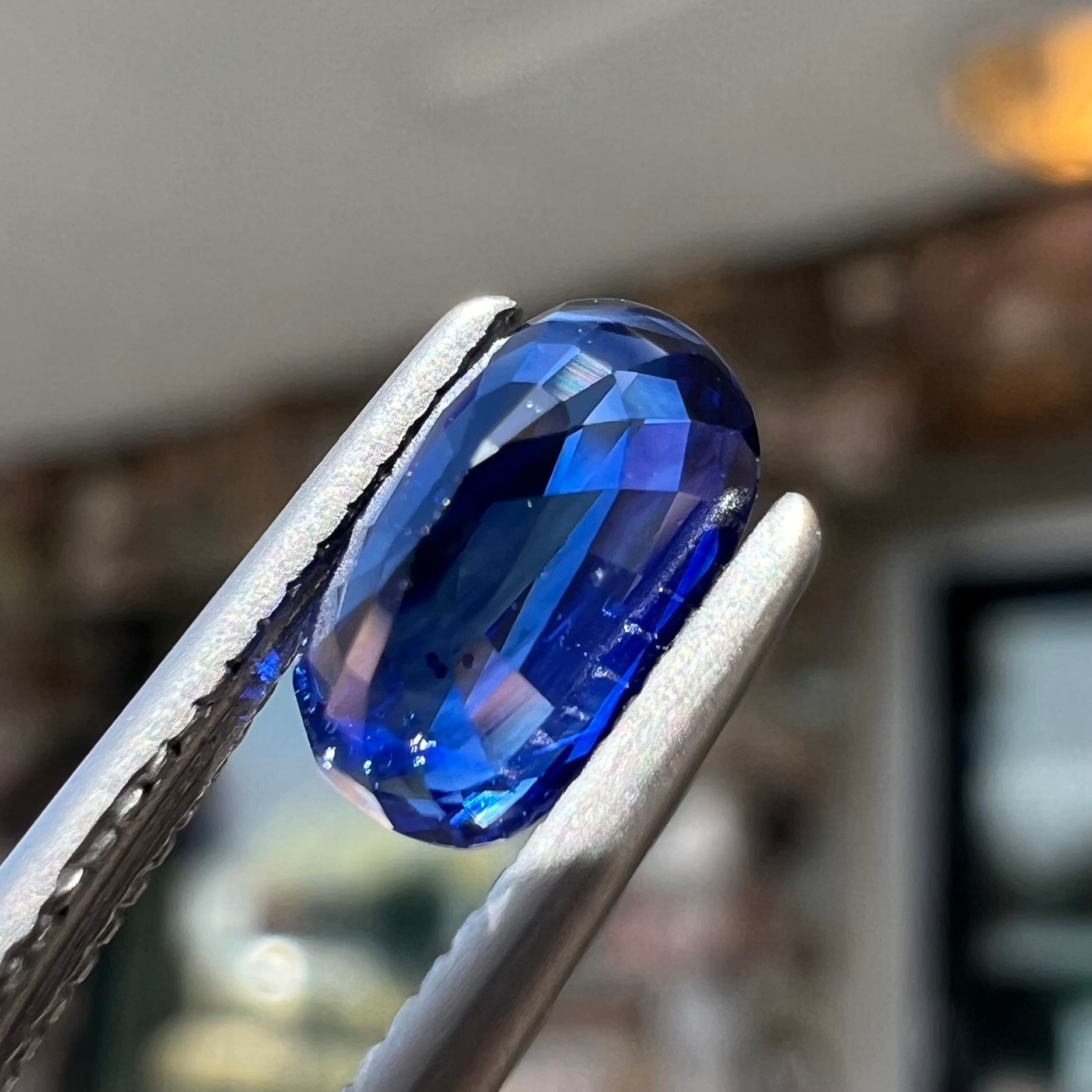 A loose, elongated oval cut blue sapphire gemstone.