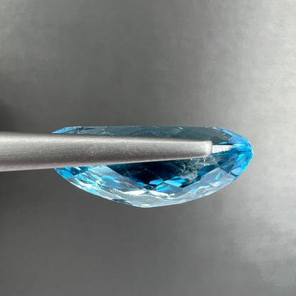 A loose, marquise cut blue topaz gemstone.