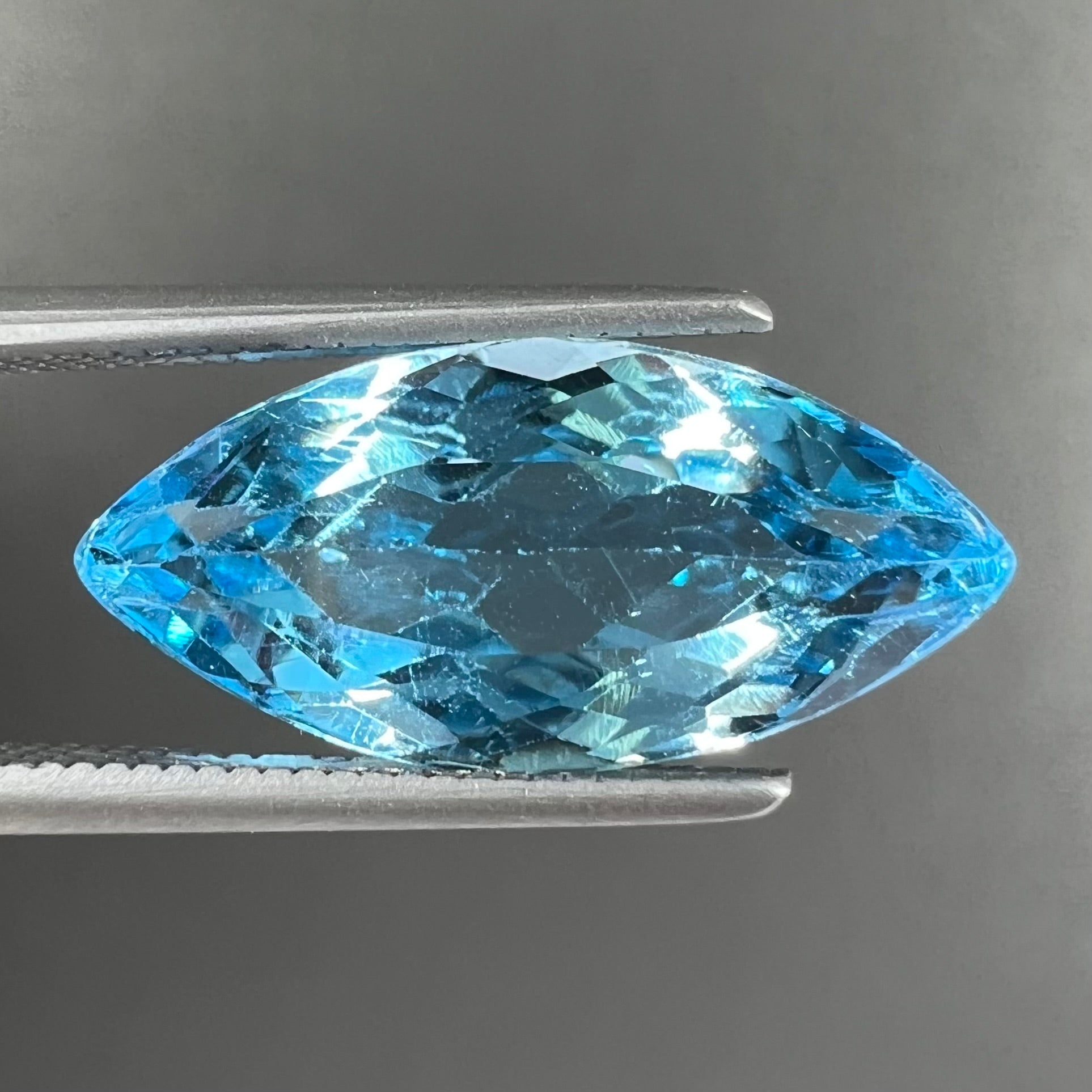 A loose, marquise cut blue topaz gemstone.