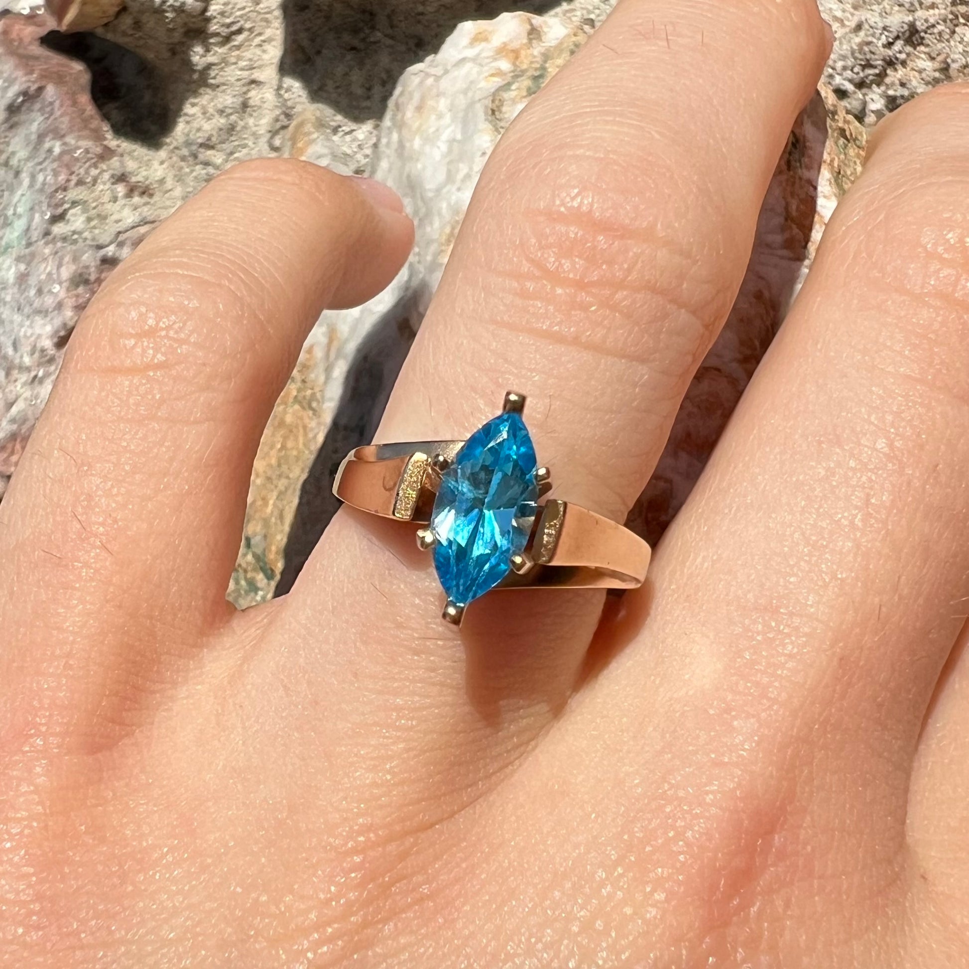 A ladies' estate yellow gold ring, prong set with a marquise cut blue topaz stone.  There are scratches on the shank.