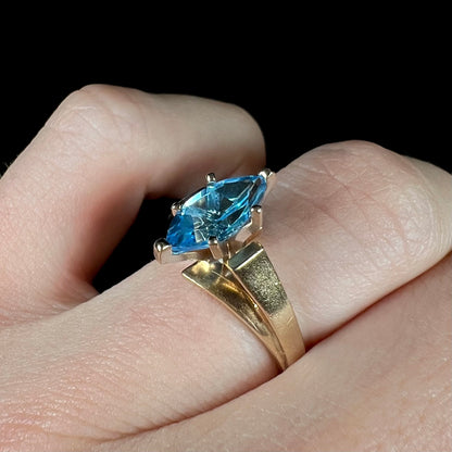 A ladies' estate yellow gold ring, prong set with a marquise cut blue topaz stone.  There are scratches on the shank.