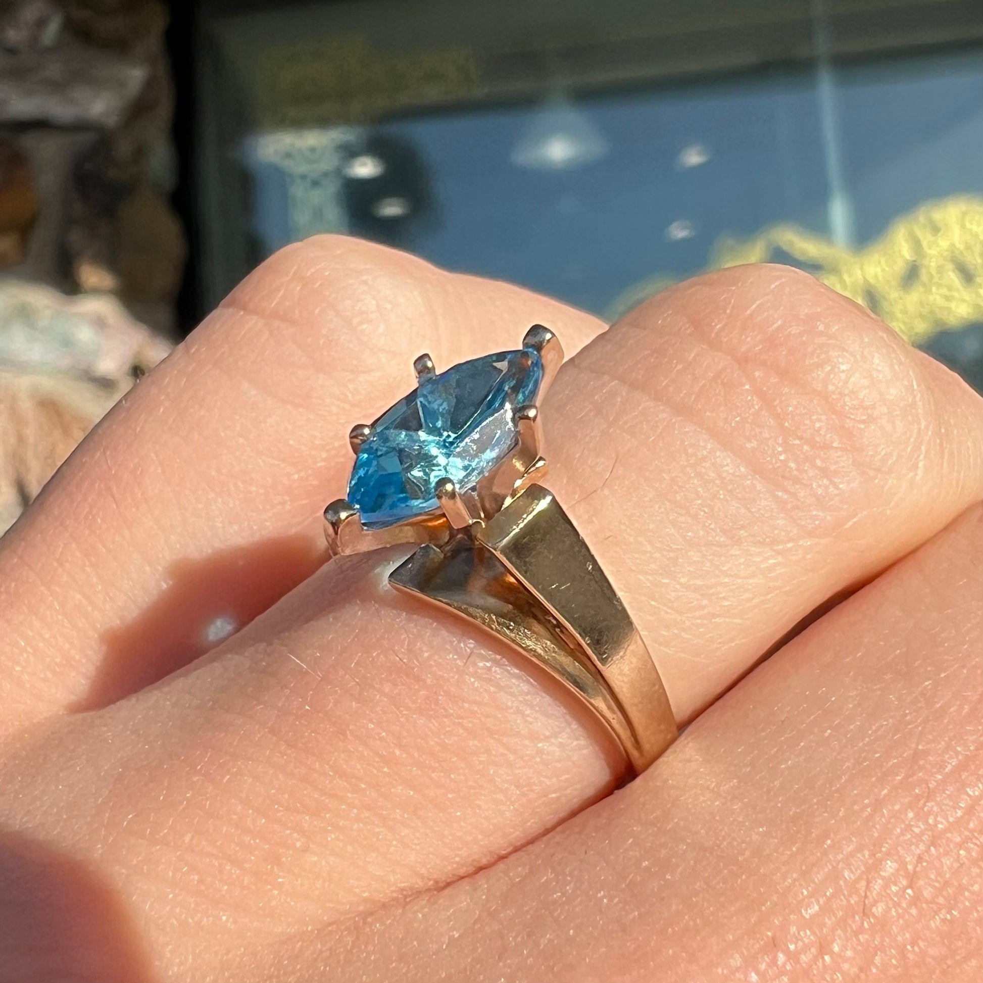 A ladies' estate yellow gold ring, prong set with a marquise cut blue topaz stone.  There are scratches on the shank.