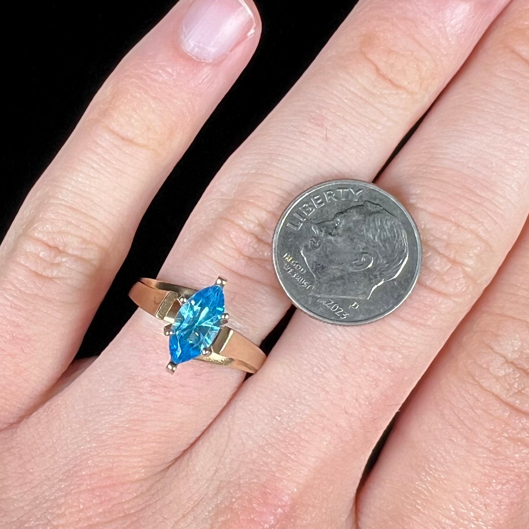 A ladies' estate yellow gold ring, prong set with a marquise cut blue topaz stone.  There are scratches on the shank.