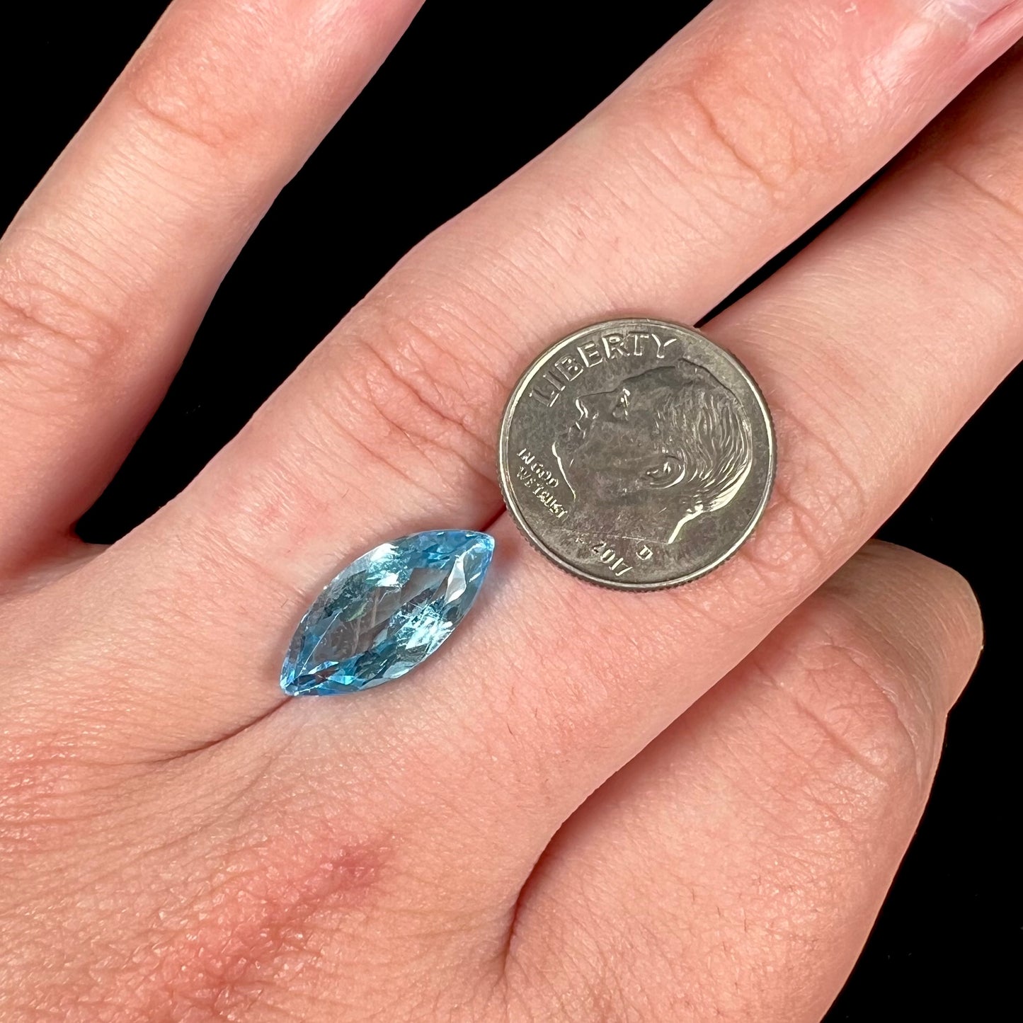 A loose, marquise cut blue topaz gemstone.