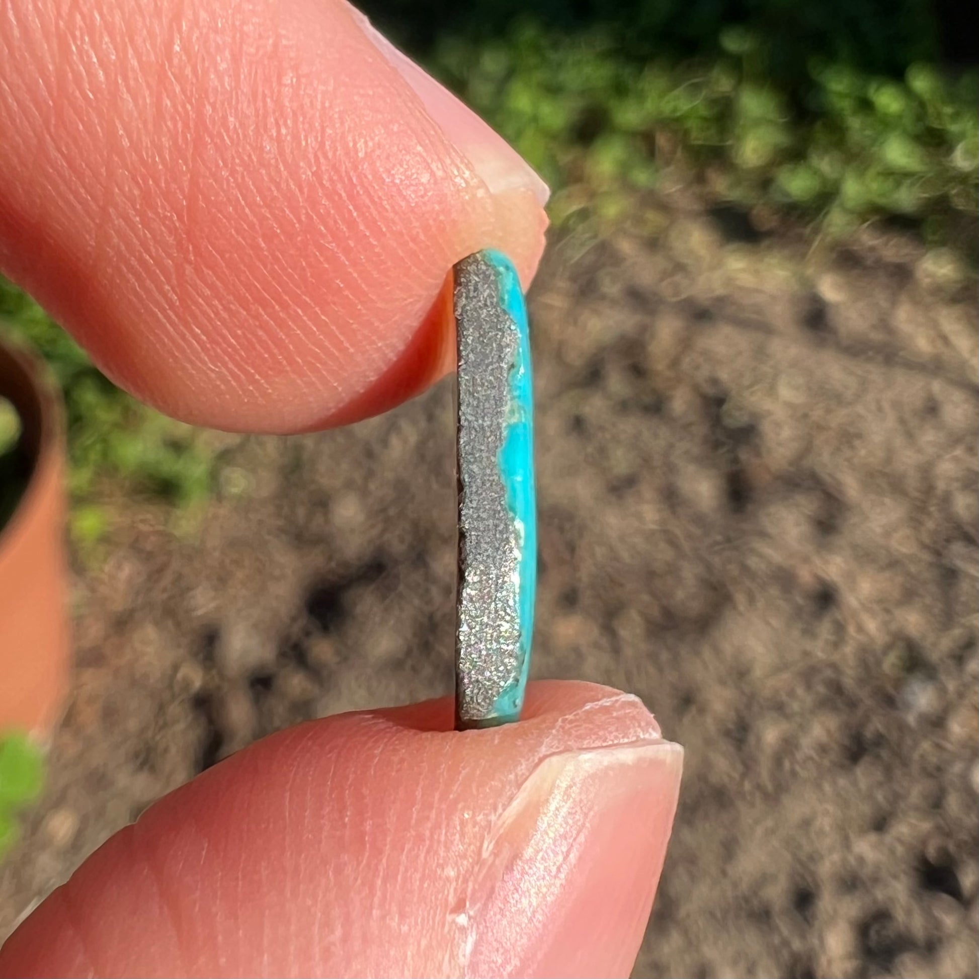 A loose, freeform cabochon cut Kingman turquoise stone.  The stone is bright blue.