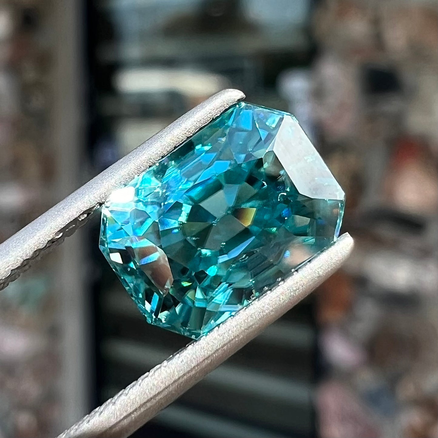 A loose, modified emerald cut blue zircon gemstone.  The stone has a large belly.