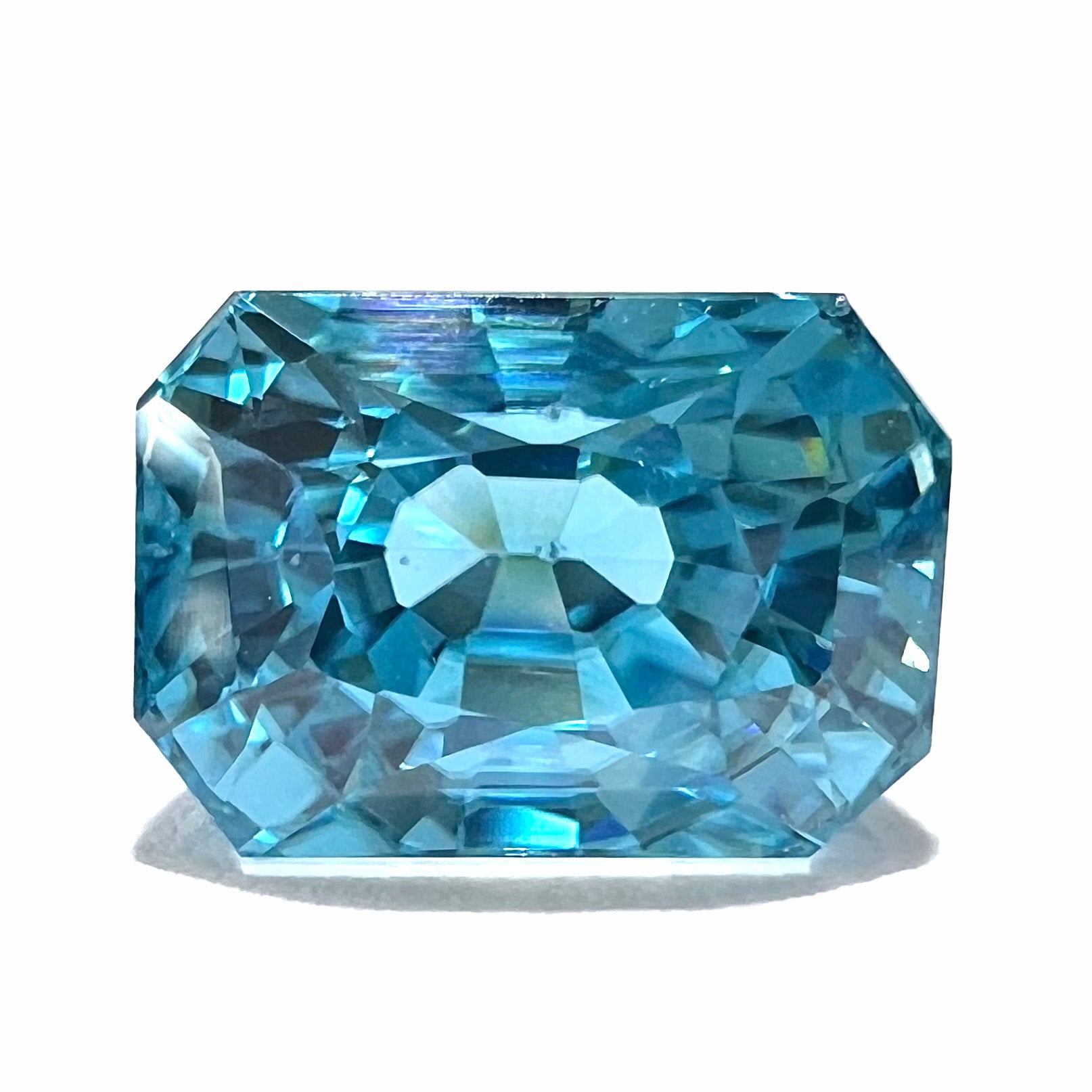 A loose, modified emerald cut blue zircon gemstone.  The stone has a large belly.