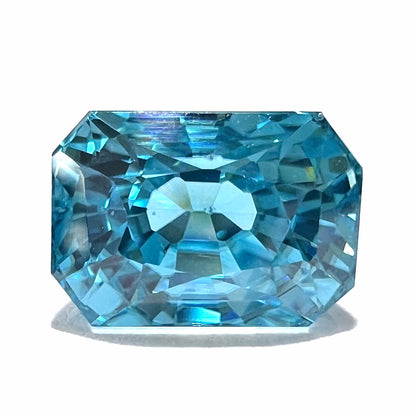 A loose, modified emerald cut blue zircon gemstone.  The stone has a large belly.