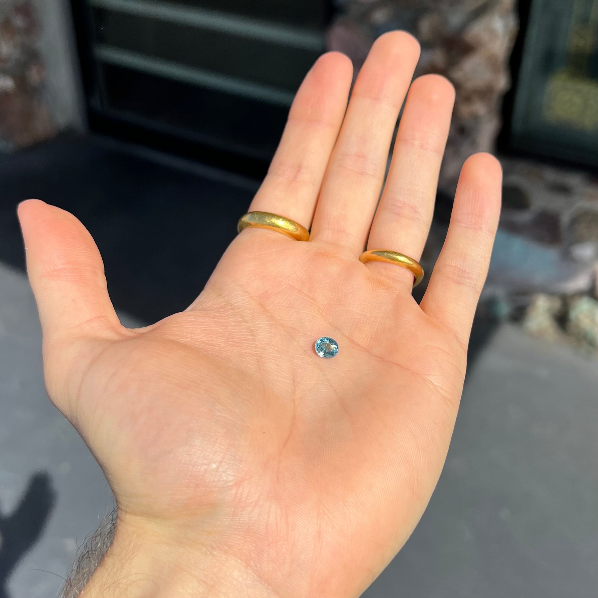 A loose, faceted oval cut blue zircon gemstone.