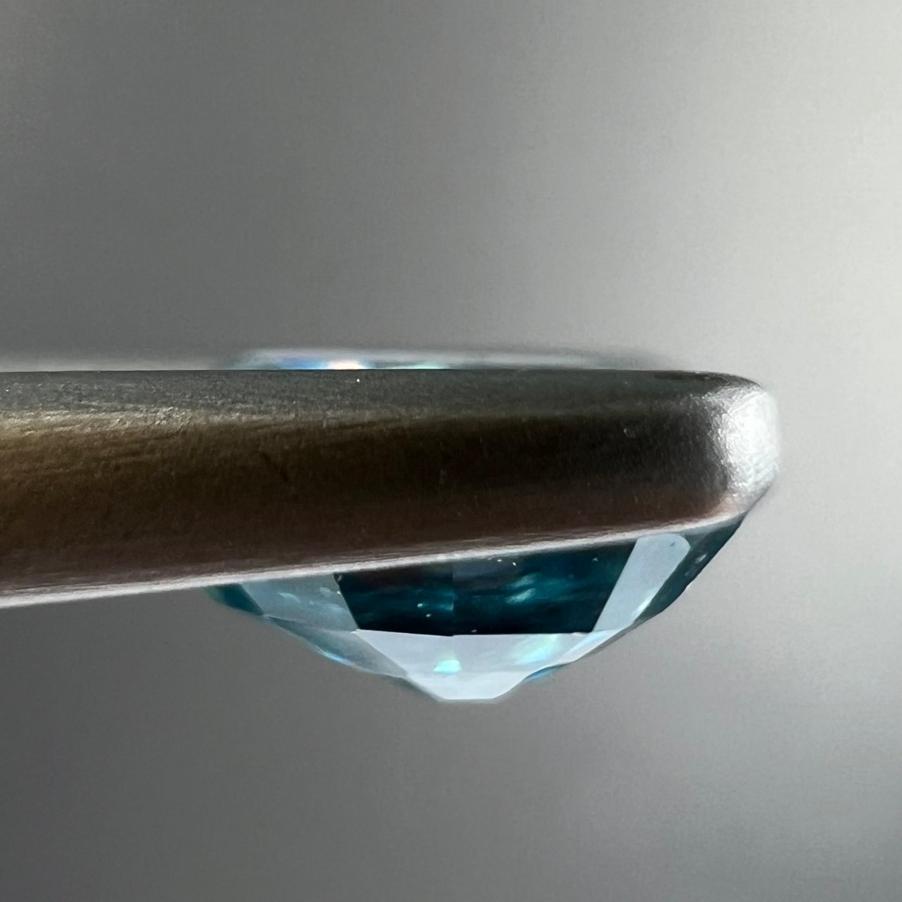 A loose, faceted oval cut blue zircon gemstone.