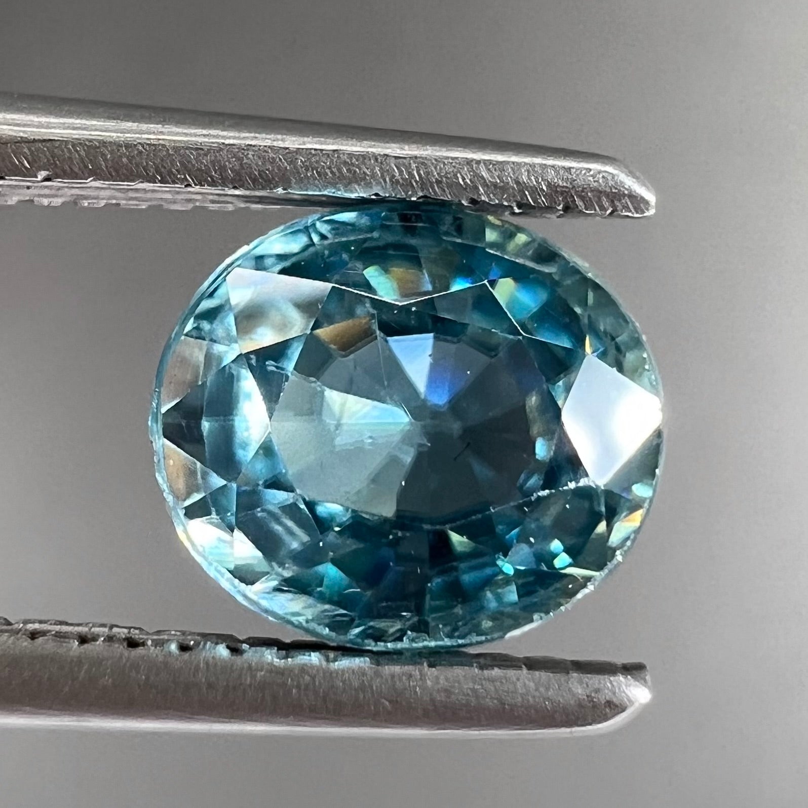 A loose, faceted oval cut blue zircon gemstone.