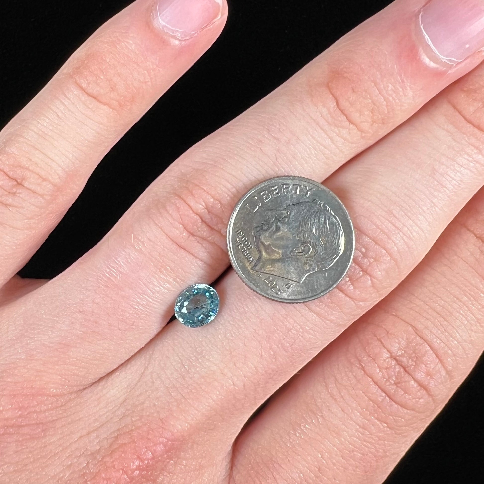 A loose, faceted oval cut blue zircon gemstone.