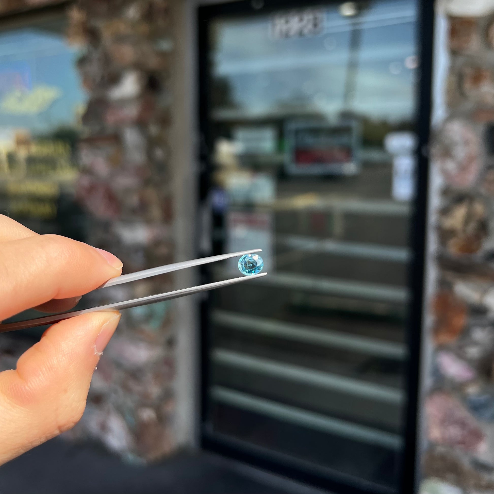 A loose, faceted oval cut blue zircon gemstone.