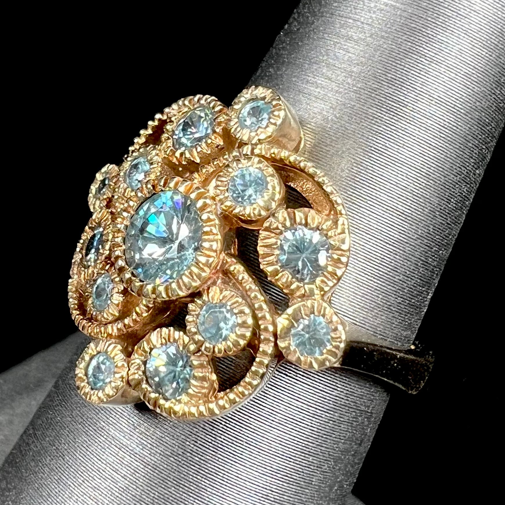 A ladies' yellow gold estate cluster ring set with natural blue zircon stones.
