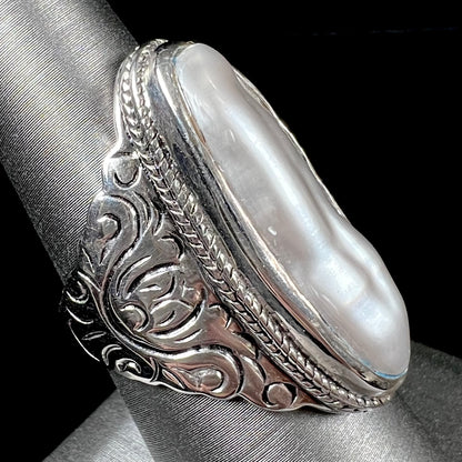 A Boho Chic style sterling silver solitaire ring set with an oval shaped, metallic silver gray mabe pearl.