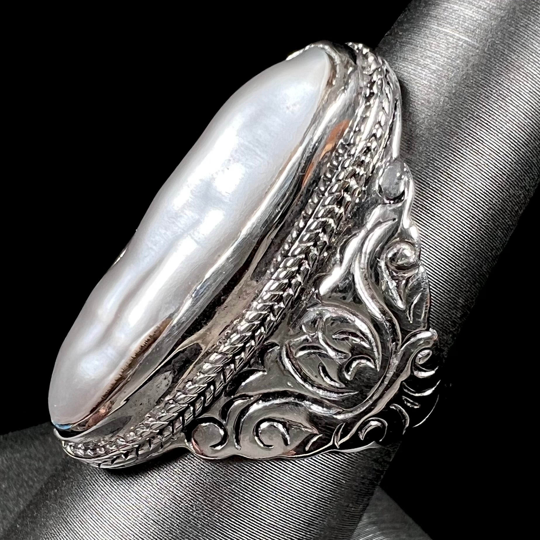 A Boho Chic style sterling silver solitaire ring set with an oval shaped, metallic silver gray mabe pearl.