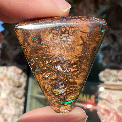 A triangle shaped Koroit boulder opal.  The stone has blue veins of opal running through it.