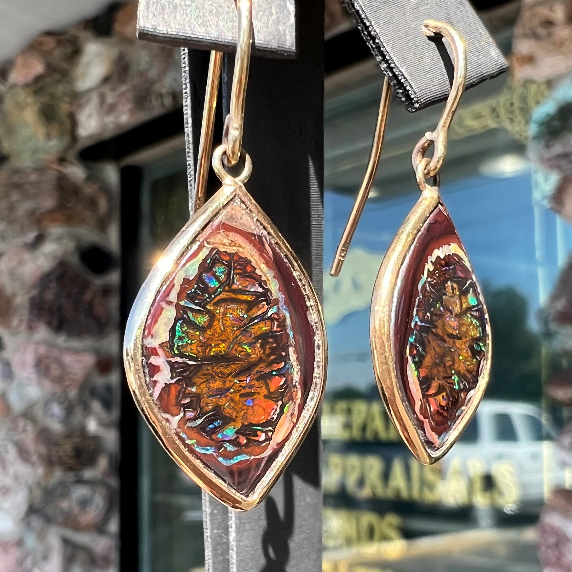 A pair of yellow gold dangle earrings bezel set with natural boulder opals from Koroit, Australia.