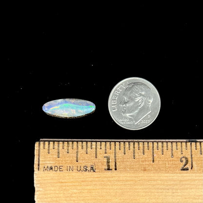 A loose, marquise cut boulder opal from Quilpie, Australia.  The opal has green and red wave patterns.