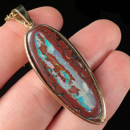 A yellow gold pendant set with a natural Yowah nut boulder opal stone.