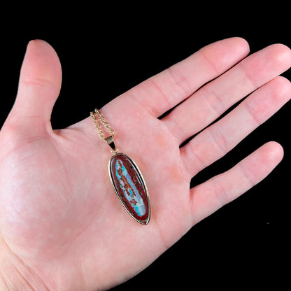 A yellow gold pendant set with a natural Yowah nut boulder opal stone.