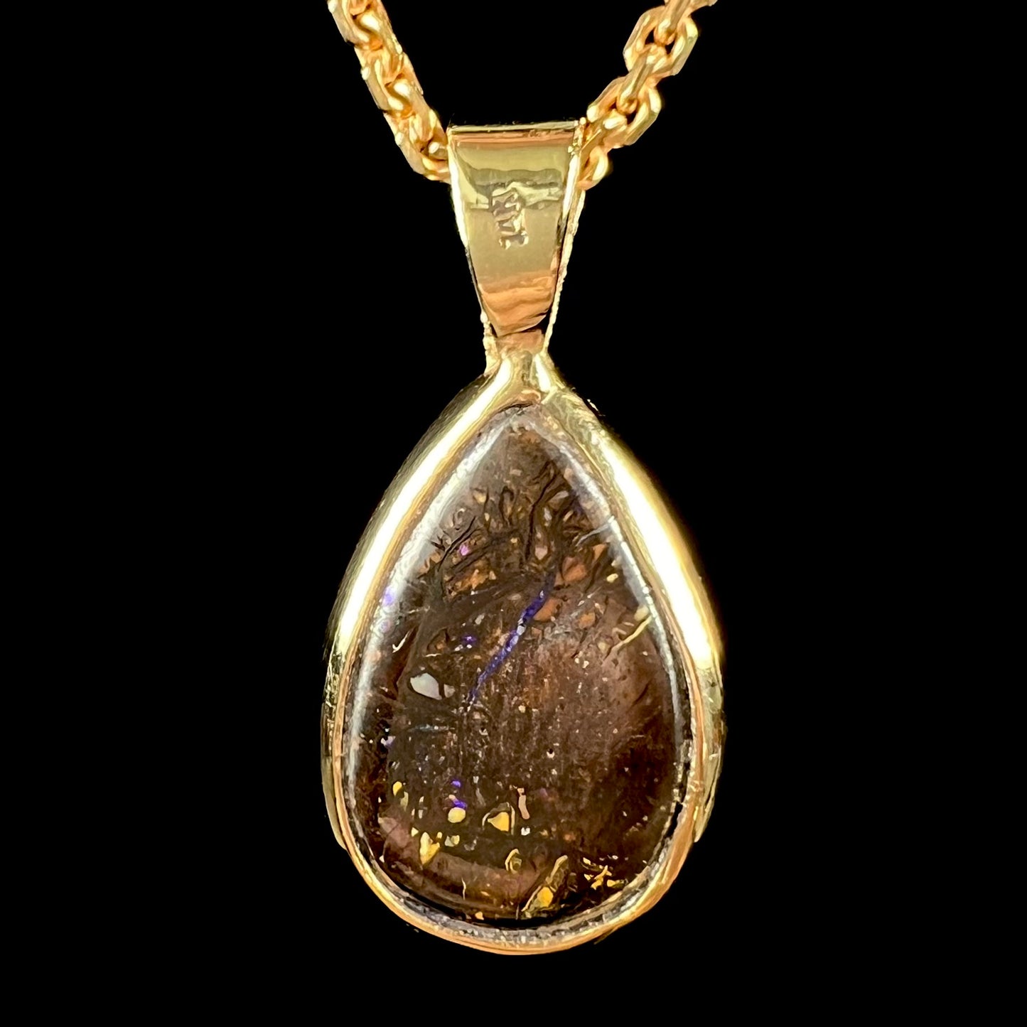A ladies' yellow gold pendant set with a natural Koroit, Australian boulder opal and a tsavorite garnet accent stone.