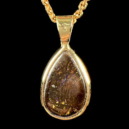 A ladies' yellow gold pendant set with a natural Koroit, Australian boulder opal and a tsavorite garnet accent stone.